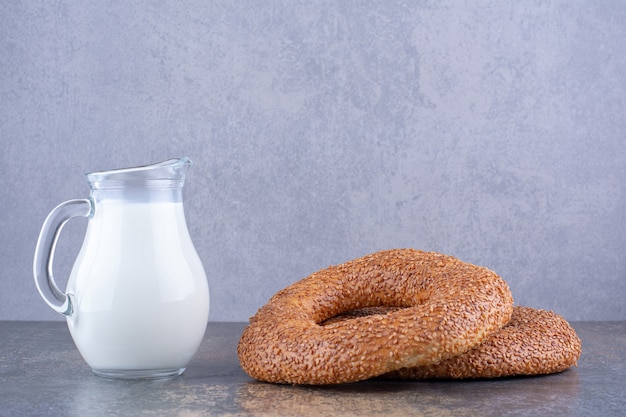 Bagels de gergelim com um pote de leite à parte