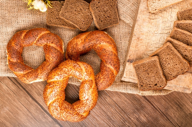 Bagels e fatias de pão na cesta e na toalha de mesa