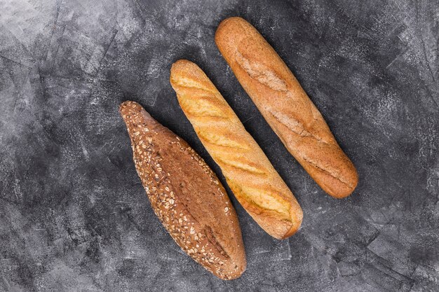 Baguete e pão no pano de fundo resistido