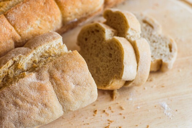 Baguete fatiada na mesa de madeira de perto