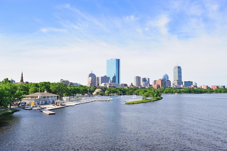 Foto grátis baía de boston com barco à vela e skyline da cidade de construção urbana pela manhã.