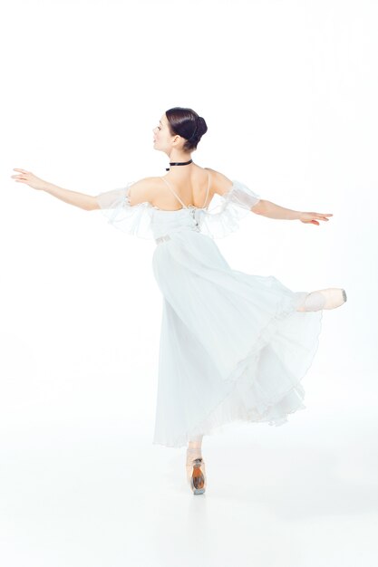Bailarina em vestido branco, posando em sapatilhas