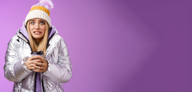 Foto grátis balançando uma garota desconfortável e descontente usando um elegante chapéu de jaqueta prateada tremendo frio e quente