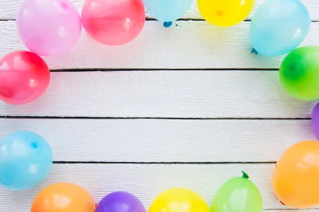 Foto grátis balões coloridos decorados na prancha de madeira branca