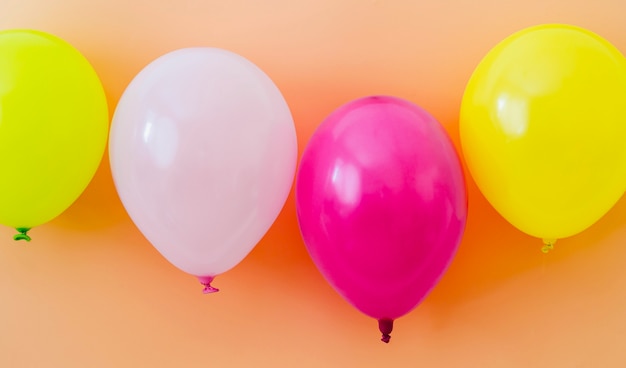 Balões coloridos em fundo laranja