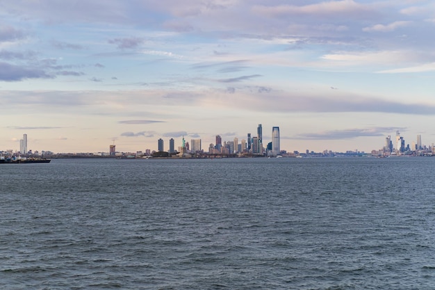 Balsa para Manhattan. Vista de Manhattan da água ao pôr do sol, Nova York, EUA