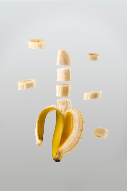 Foto grátis banana fatiada flutuante com fundo claro