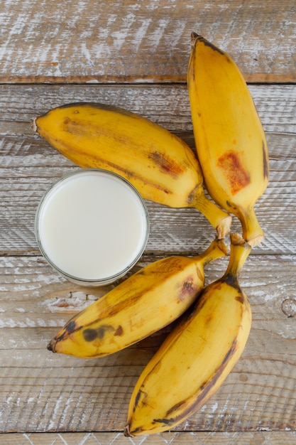 Bananas maduras com leite na madeira,