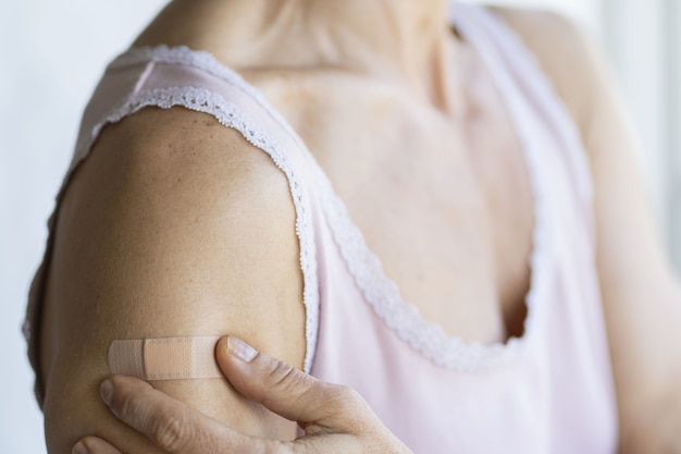 Bandagem no braço de uma mulher ao lado de sua mão