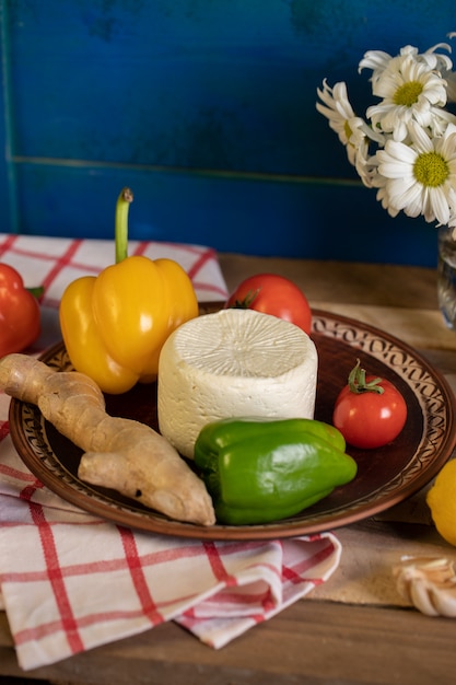 Bandeja marrom com queijo, pimenta e gengibre dentro