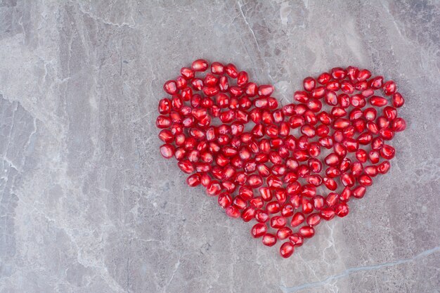 Bando de sementes de romã em forma de coração.