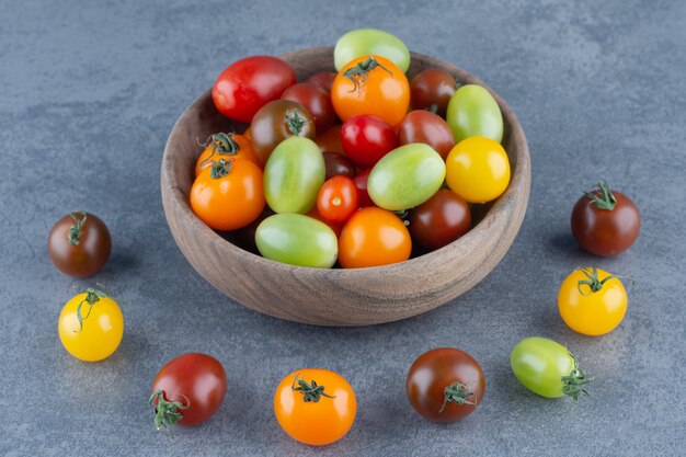 Bando de tomates coloridos em uma tigela de madeira.