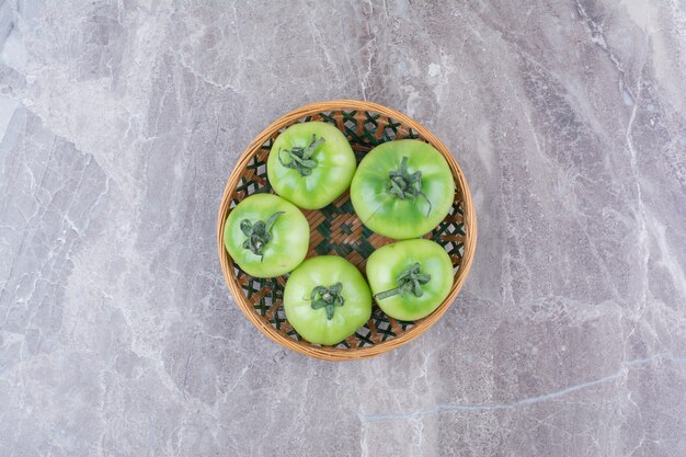 Bando de tomates verdes em uma tigela de cerâmica.