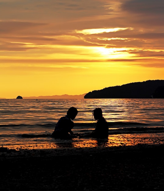 Banhistas ao pôr do sol