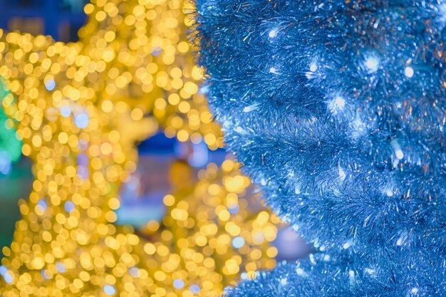 Banner web de Feliz Natal e Ano Novo turva fundo de guirlandas amarelas e azuis brilhantes