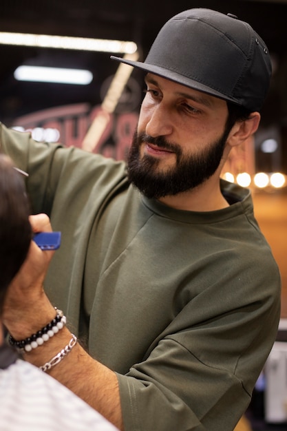 Foto grátis barbeiro dando um belo corte de cabelo em seu cliente