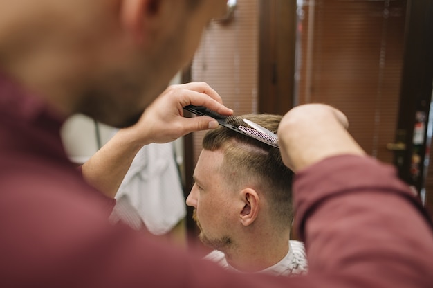 Foto grátis barbeiro dando um corte de cabelo a um cliente