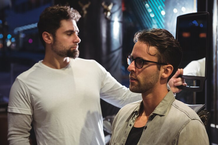 Foto grátis barbeiro mostrando o corte de cabelo do homem no espelho