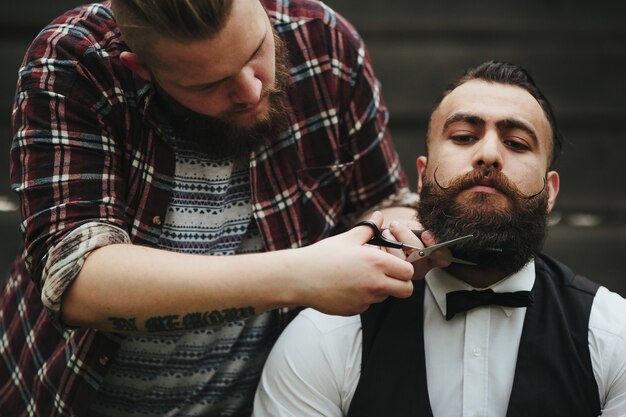 Barber usando uma tesoura para retocar uma barba