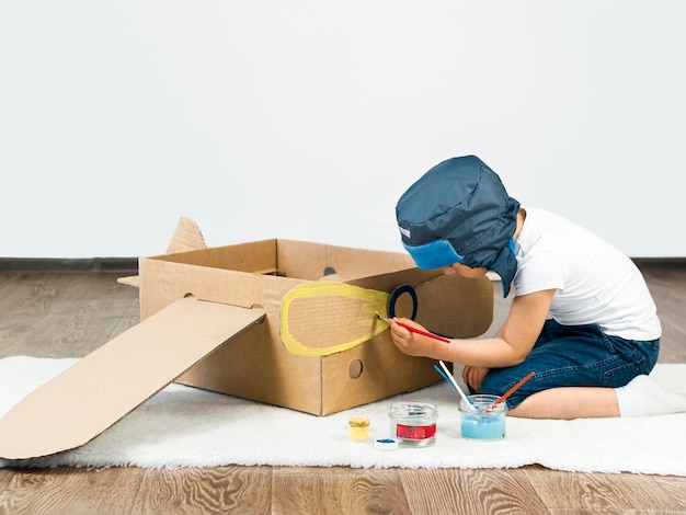 Foto grátis barco de papelão de pintura de criança