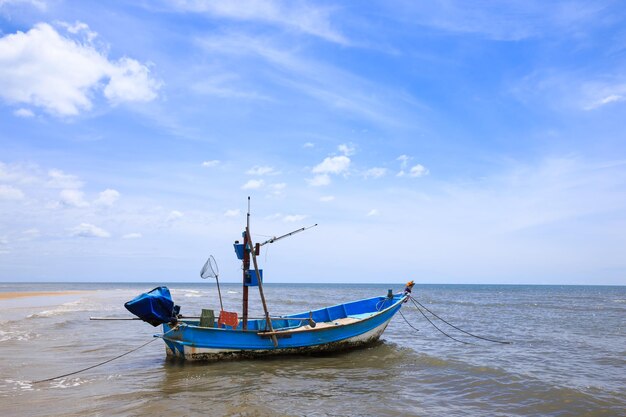 Barco de pesca tradicional flutuando na água, mar azul e céu