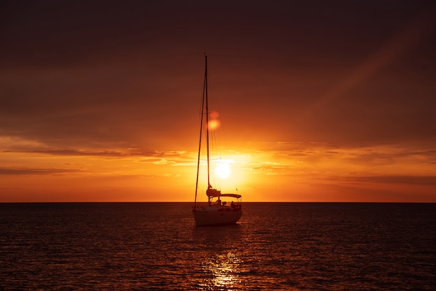 Barco de transporte no mar ao pôr do sol