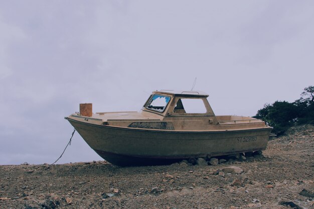 Barco marrom vintage em uma superfície rochosa e arenosa