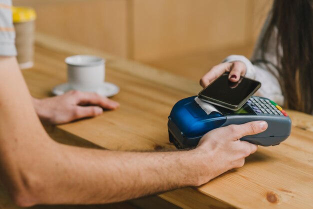 Barista aceitando pagamento com smartphone