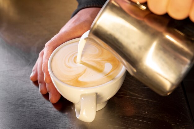 Barista de close-up, despejando café na xícara