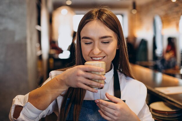 Barista preparando café com leite em uma cafeteria