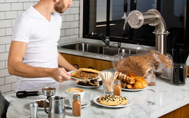 Foto grátis barista segurando na mão um prato de biscoitos