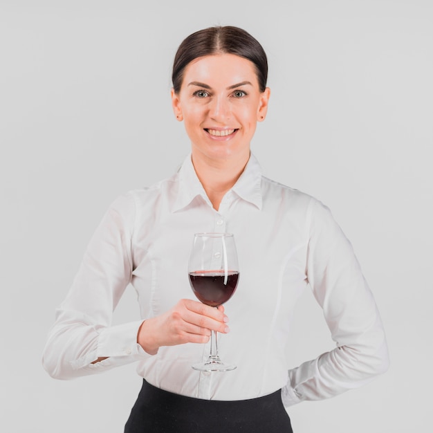 Foto grátis barkeeper sorrindo e segurando o copo de vinho