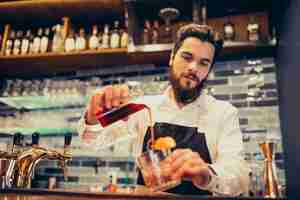 Foto grátis barman bonito fazendo beber e cocktails num balcão