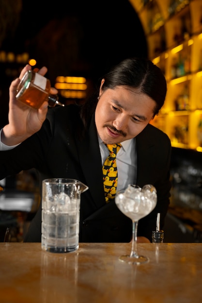 Foto grátis barman de tiro médio preparando bebida