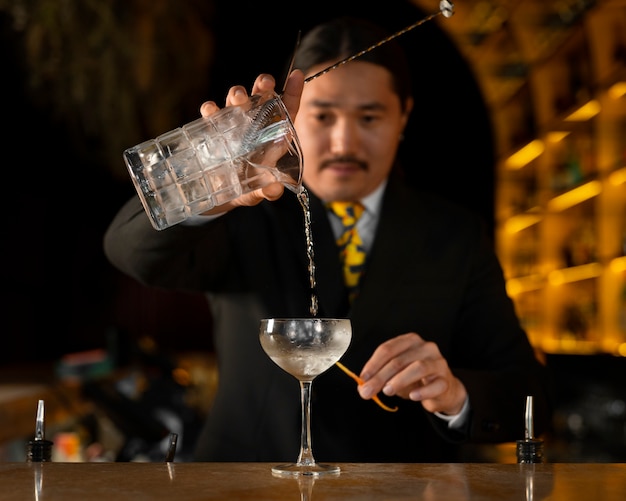 Barman de tiro médio preparando bebida