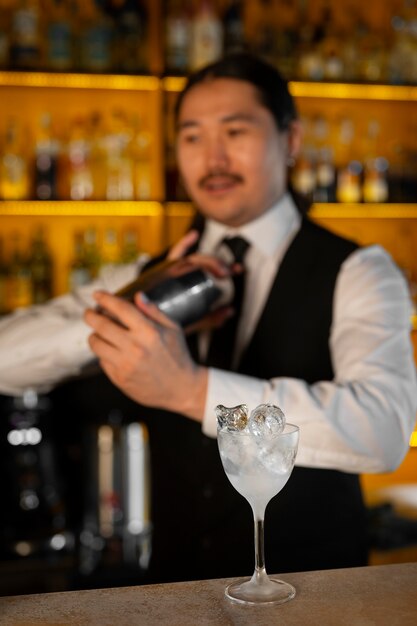 Barman de tiro médio preparando bebida