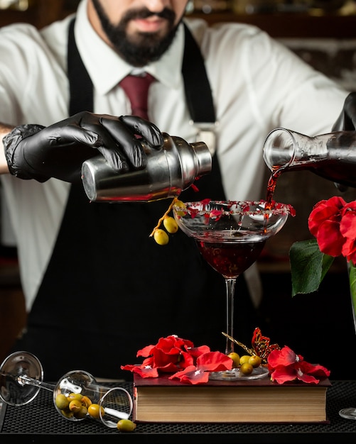 Barman derrama cocktail mistura em um copo
