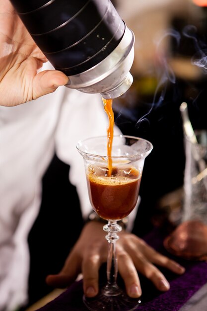 Barman fazendo bebida alcoólica e café. Derramando bebida