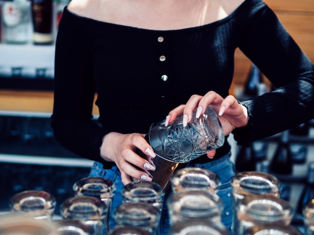 Foto grátis barman feminino derramando bebida de vidro