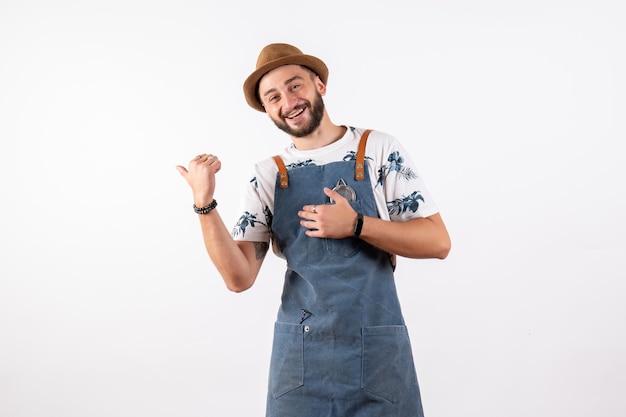 Barman masculino de frente para o salão posando com um sorriso no modelo de trabalho de bebida alcoólica à noite em bar de parede branca