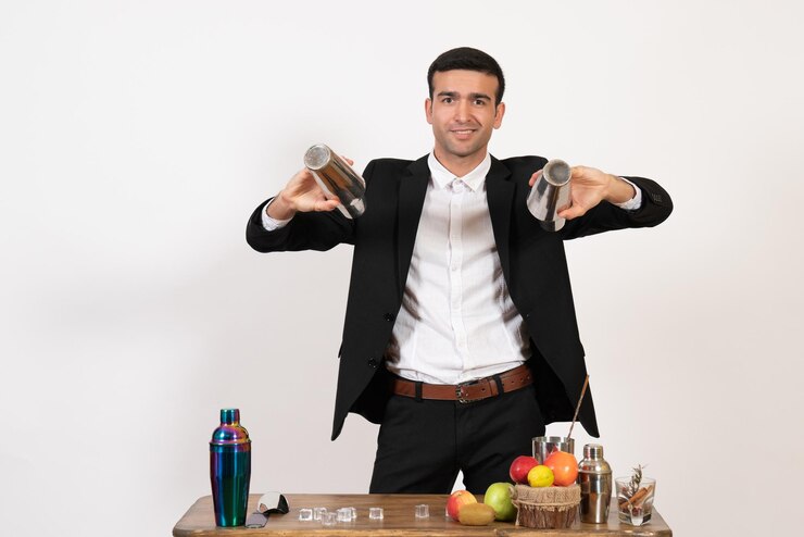 Foto grátis barman masculino de terno, de frente, trabalhando com coquetéis e fazendo bebidas na parede branca do bar de dança de boate masculino
