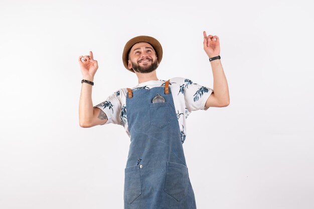 Barman masculino posando com uma expressão encantada na parede branca de bar branco em um clube noturno de bebida alcoólica