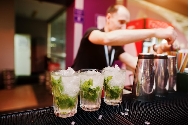 Barman preparando coquetel mojito no bar