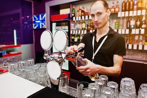 Barman serve uma cerveja no bar do clube