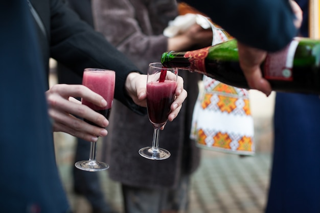 Barmen derramando vinho em óculos para noivo e convidados no casamento