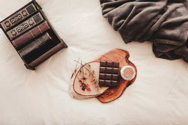 Foto grátis barra de chocolate perto de livros e cobertor