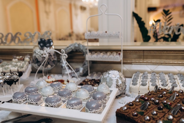 Foto grátis barra de doce com sobremesas mousse cinza, bolo de chocolate e doces pop