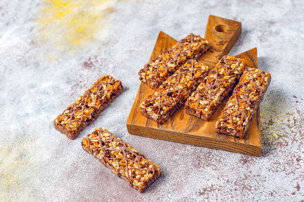 Barras de granola delicios saudáveis com chocolate, barras de cereais com nozes e frutas secas, vista superior