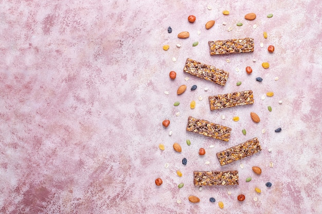 Foto grátis barras de granola deliciosas saudáveis com chocolate, barras de cereais com nozes e frutas secas, vista superior