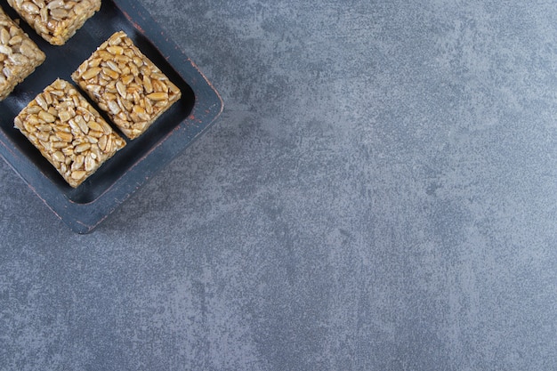 Barras de granola em uma placa de madeira na superfície de mármore